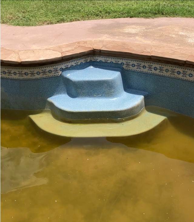 Dated pool resurfaced with new plaster and waterline tile — before